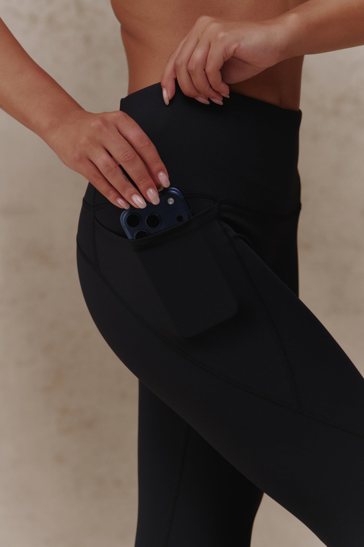 Stretch side pocket holding a phone on the Essential Leggings