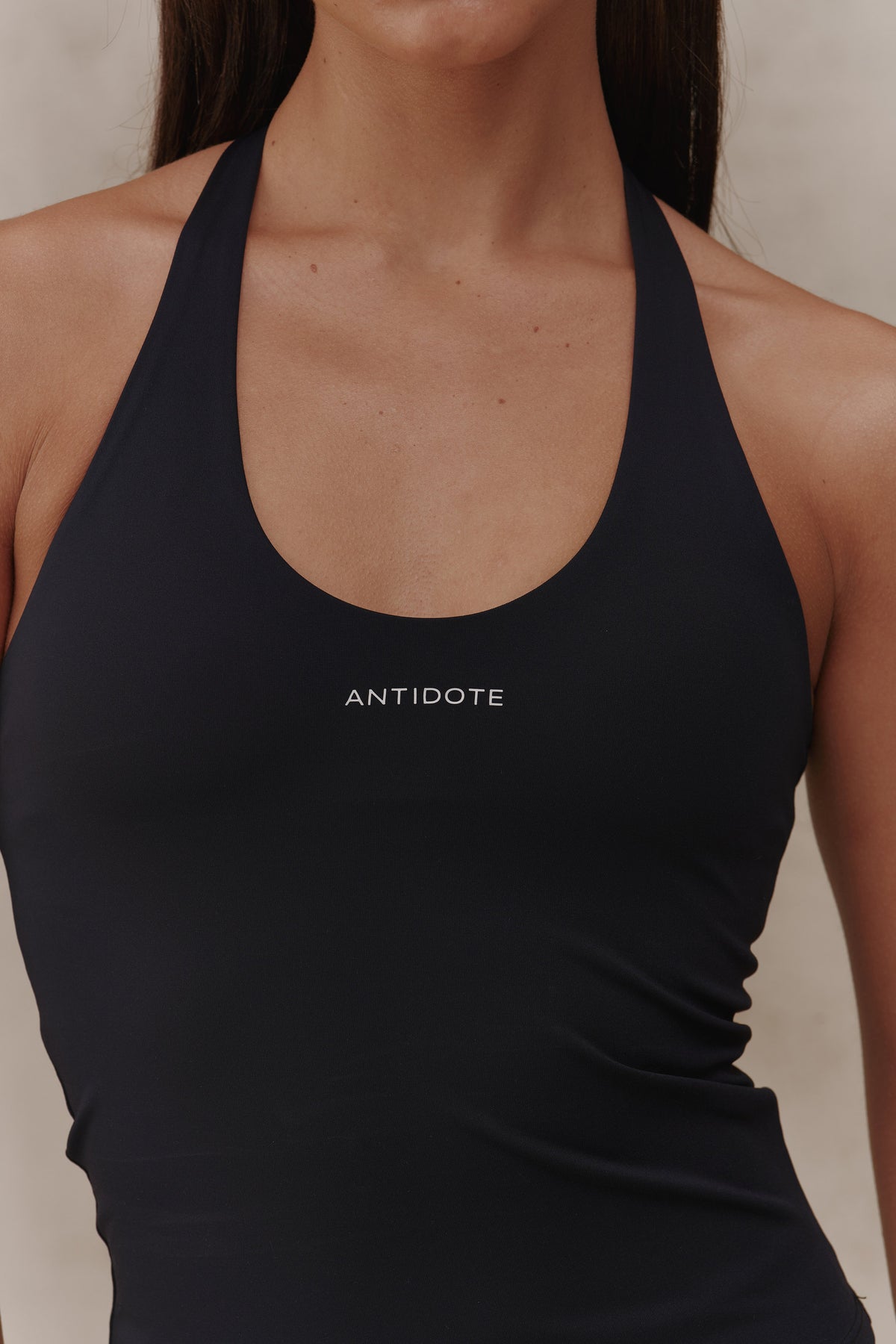 Woman wearing the Antidote Halter Neck Flow top in Black Beauty, close-up front view