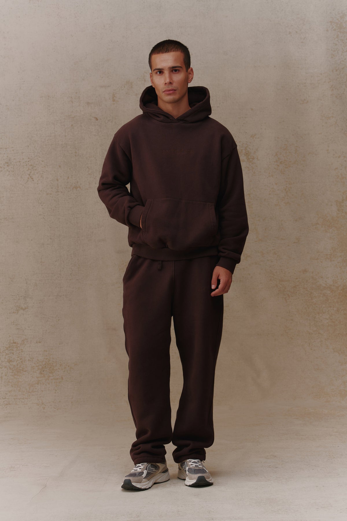 Man wearing the Antidote Recovery Hoodie in Ganache, front view