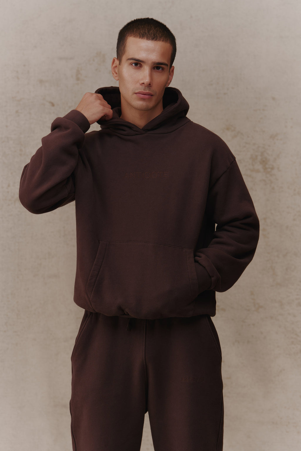 Man wearing the Antidote Recovery Hoodie in Ganache, close-up front view