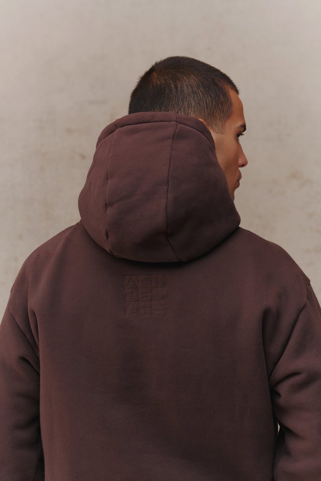 Man wearing the Antidote Recovery Hoodie in Ganache, close-up of the hood from behind