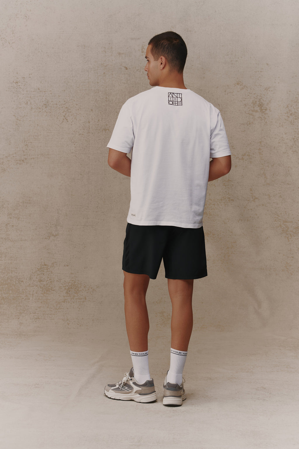 Man wearing the Antidote Reset Tee in Crisp White, back view