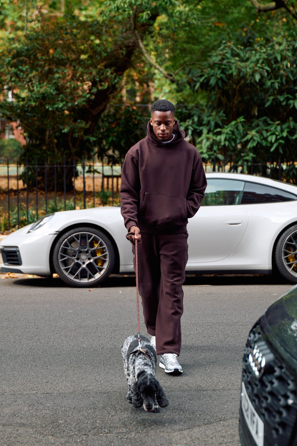 Man wearing the Antidote Men's Restore Joggers in Ganache, walking a dog