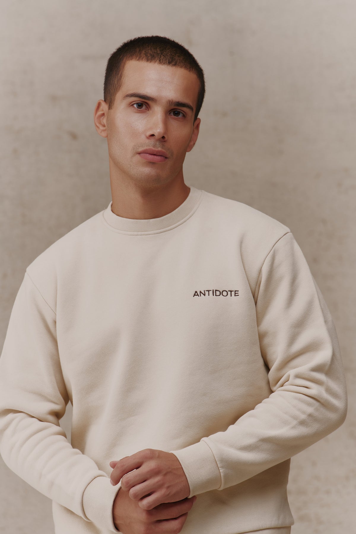 Man wearing the Antidote Revive Sweatshirt in Sand, close-up front view