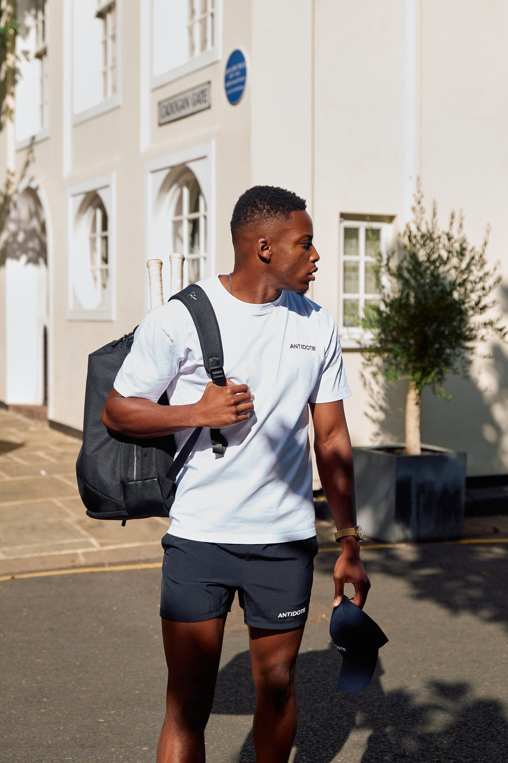 Man wearing the Antidote Motion Men's Shorts 5 inch in Noir with a kit bag