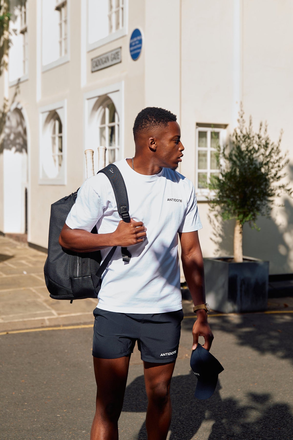 Man wearing the Antidote Motion Men's Shorts 5 inch with a tote bag