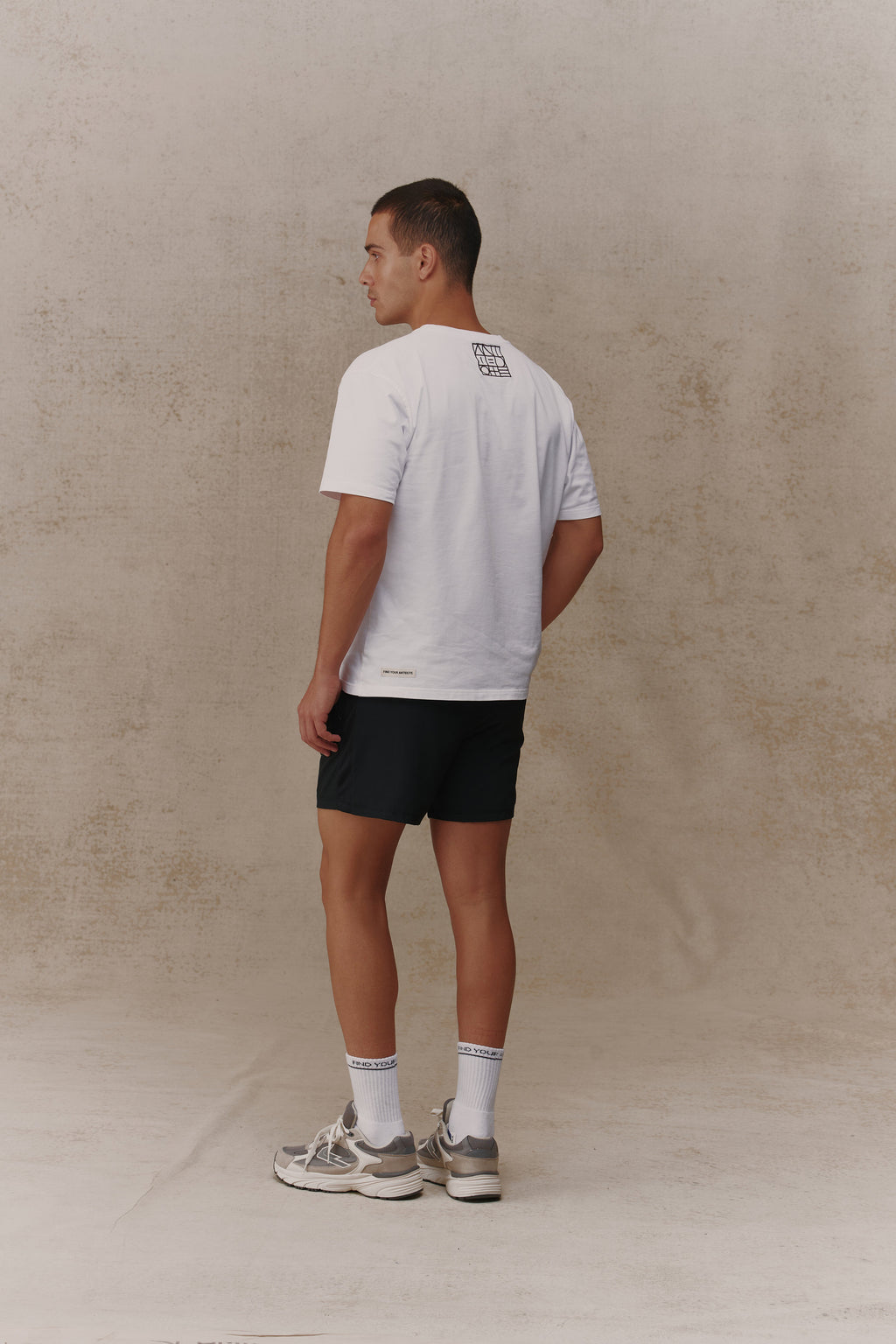 Man wearing the Antidote Motion Men's Shorts in Noir, back view