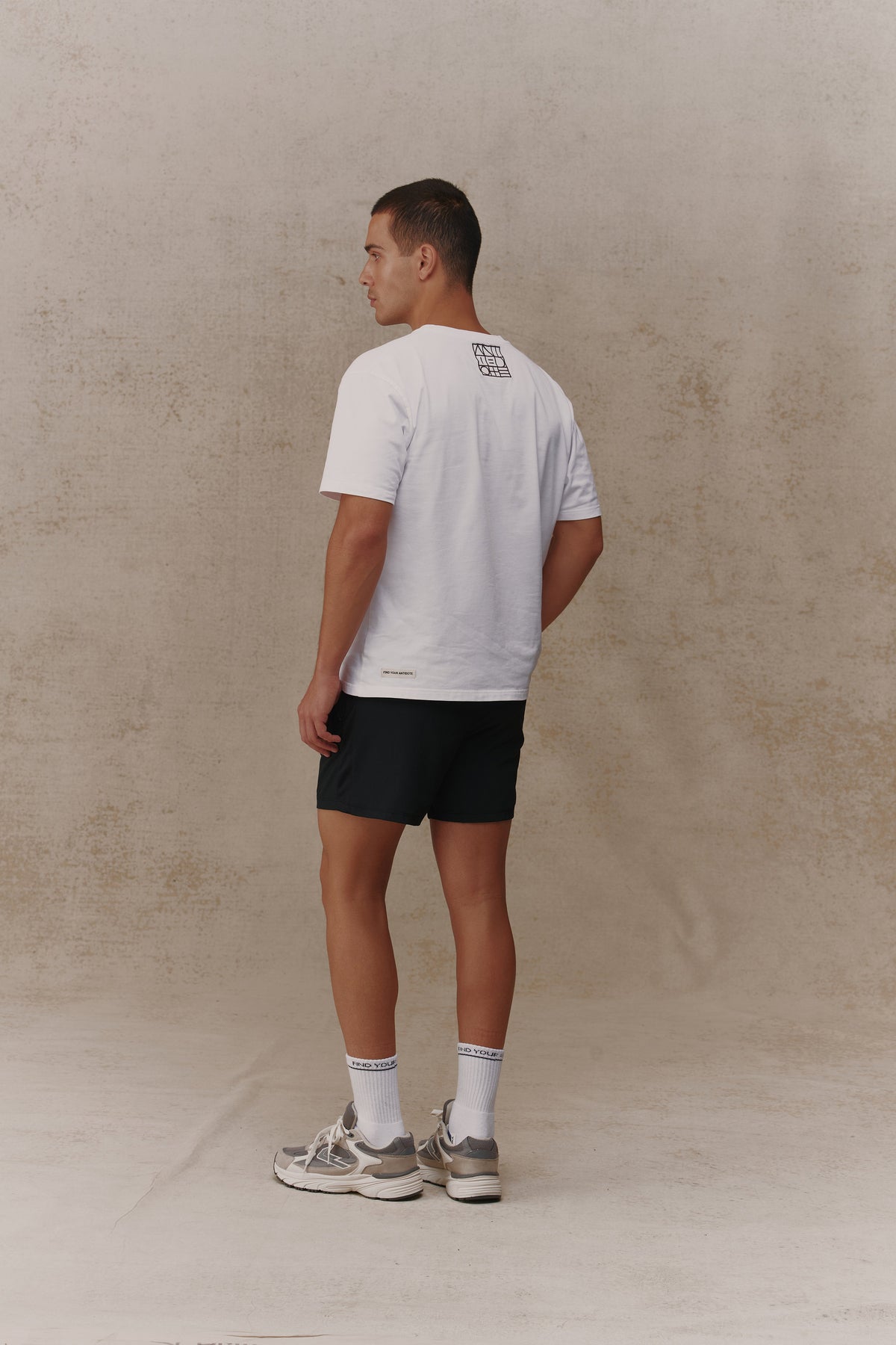 Man wearing the Antidote Motion Men's Shorts in Noir, back view