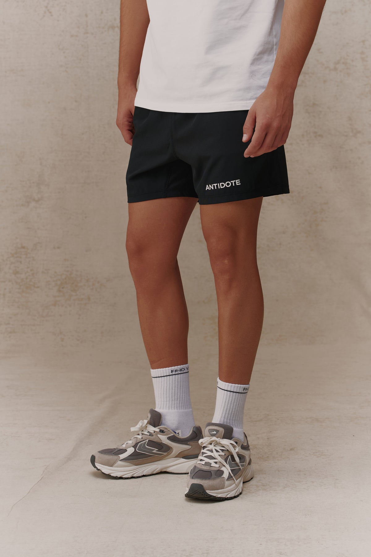 Man wearing the Antidote Motion Men's Shorts in Noir, close-up front view