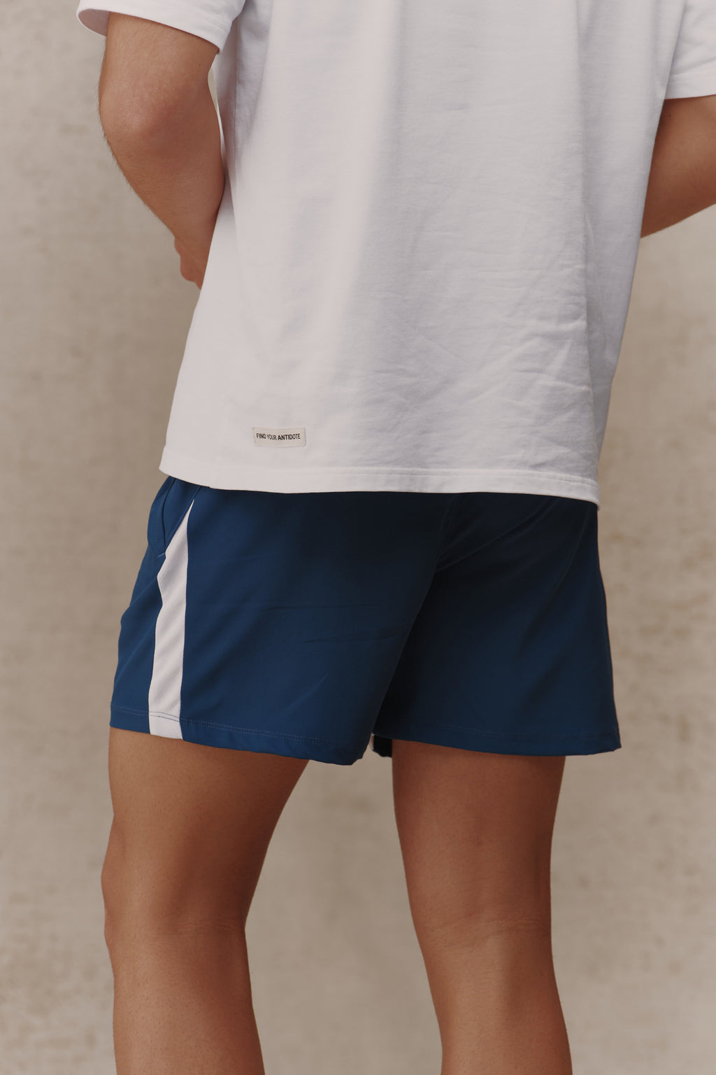 Man wearing the Antidote Motion Men's Shorts in Ocean Blue, close-up side view