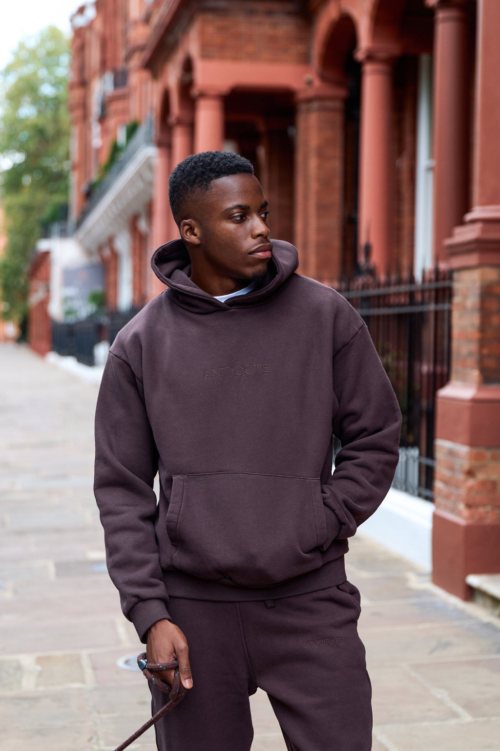 Man wearing the Antidote Recovery Hoodie in Ganache, walking a London street