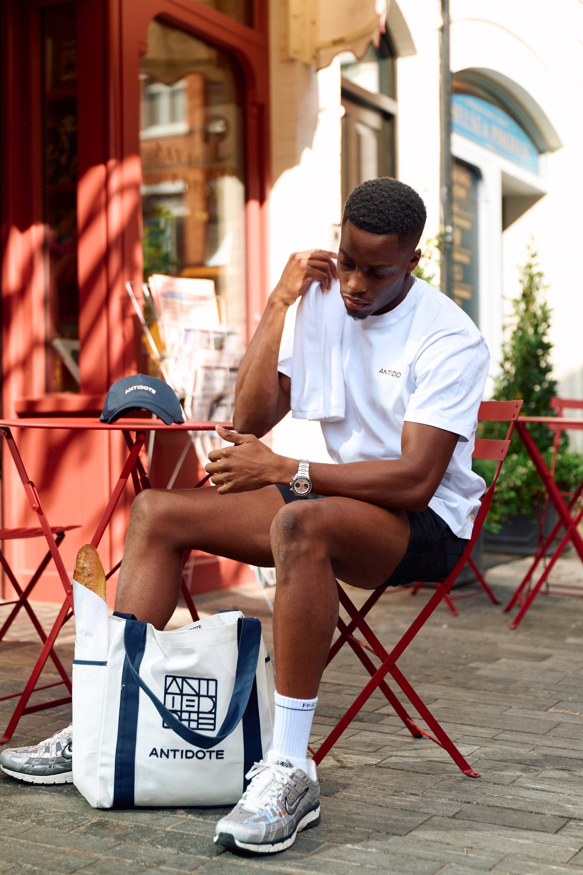 Man using the Antidote Sweat Towel outside a cafe