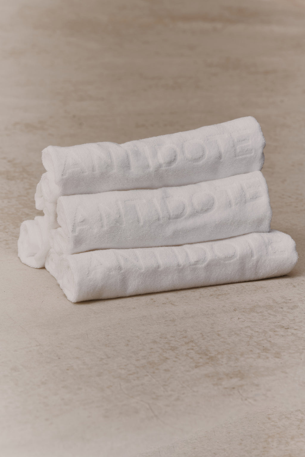 Rolled Antidote Sweat Towels with the debossed wordmark