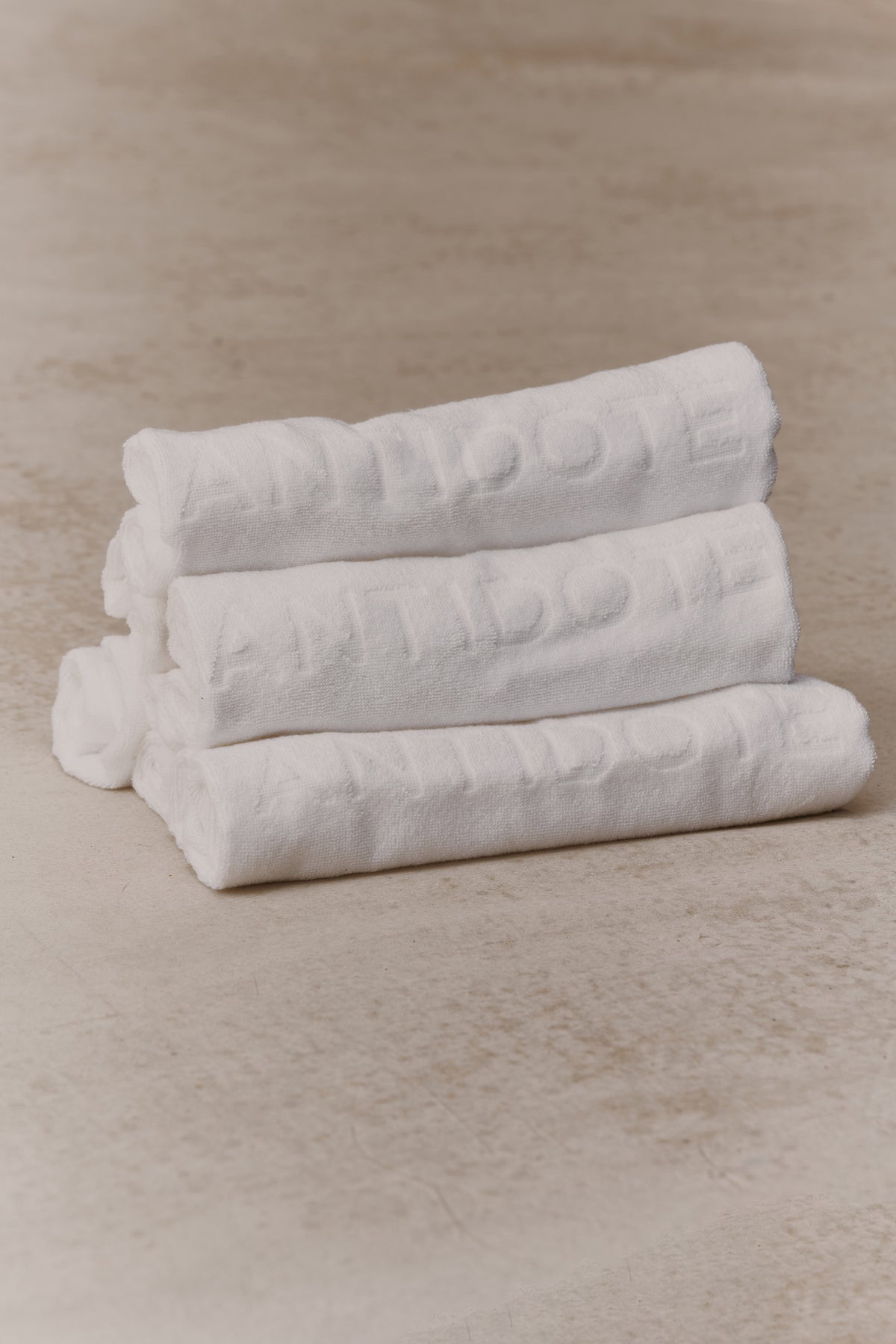 Rolled Antidote Sweat Towels with the debossed wordmark