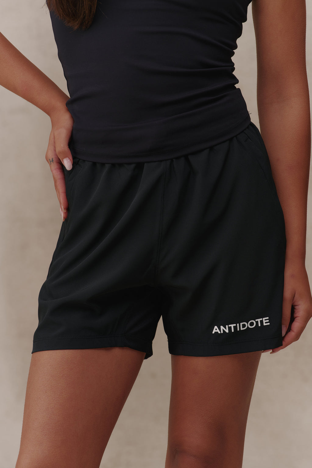 Woman wearing the Antidote Women's Motion Shorts in Noir, close-up front view
