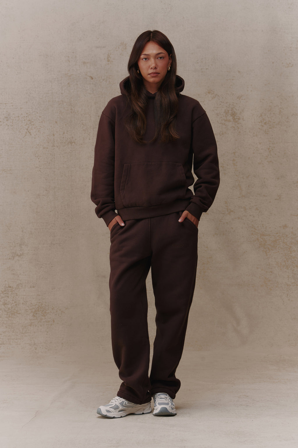 Woman wearing the Antidote Recovery Hoodie in Ganache, front view