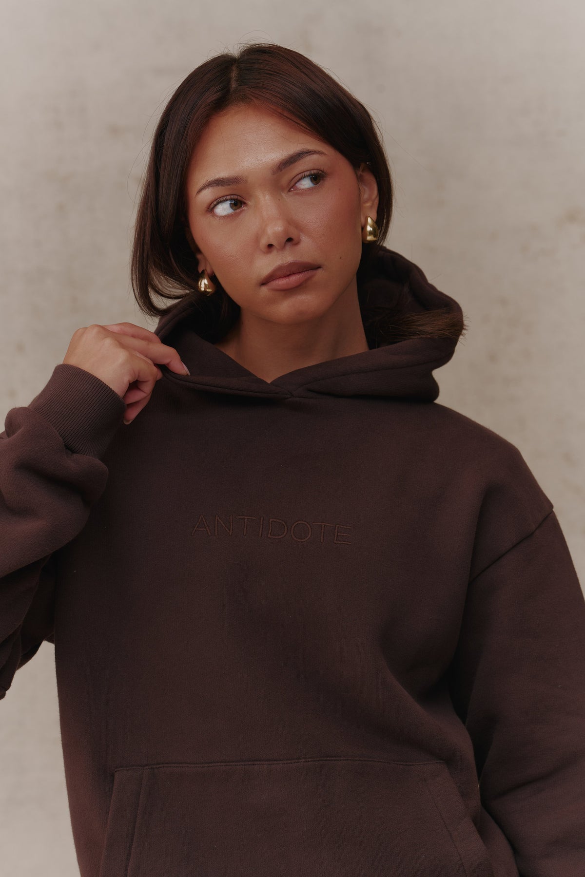 Woman wearing the Antidote Recovery Hoodie in Ganache, close-up front view