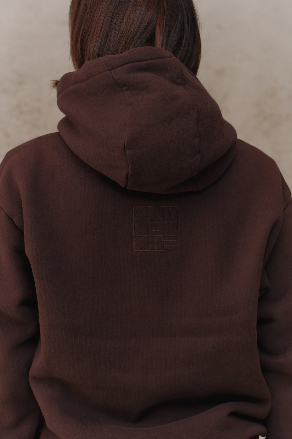 Woman wearing the Antidote Recovery Hoodie in Ganache, close-up of the hood from behind
