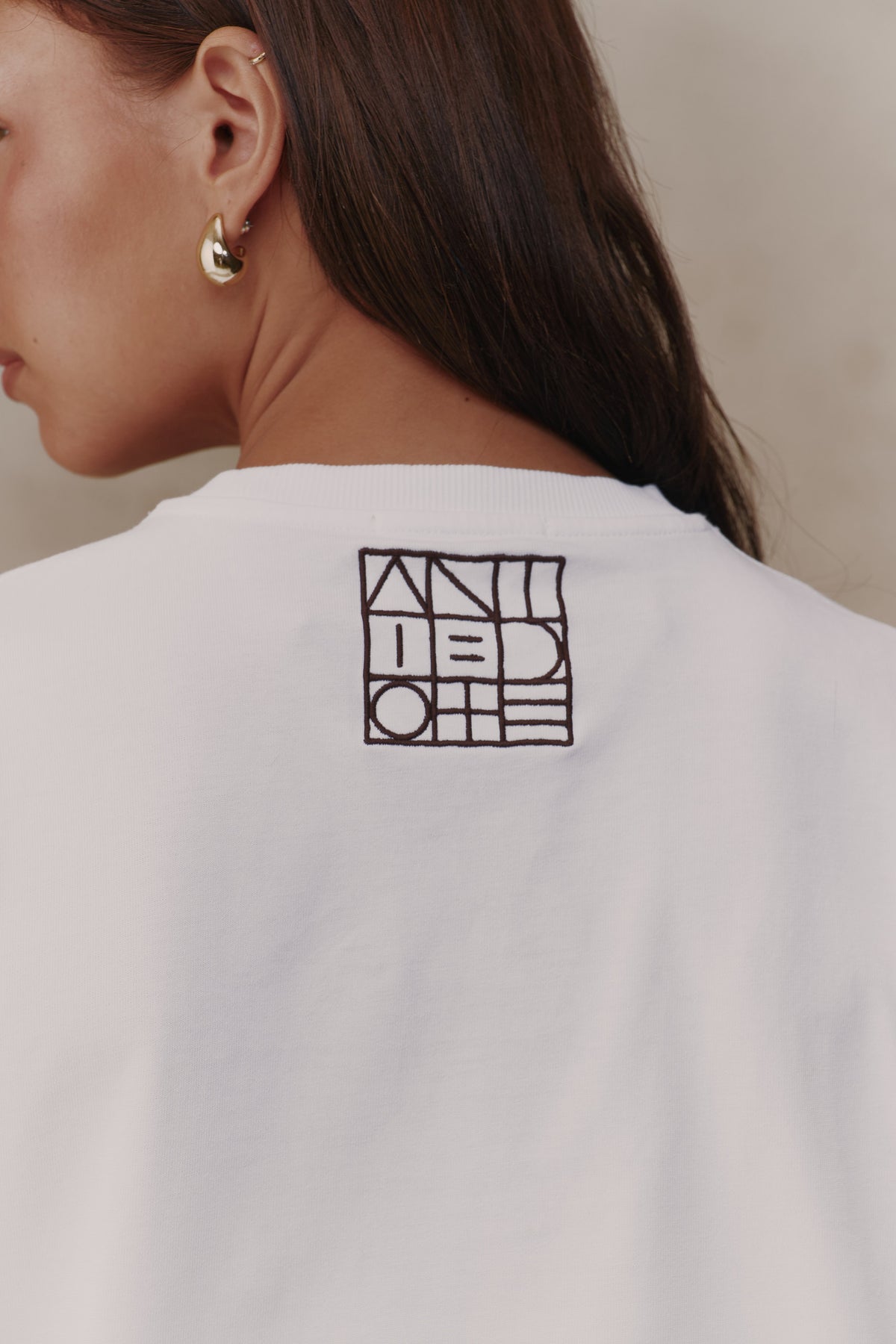 Embroidered logo on the back of the Reset Tee
