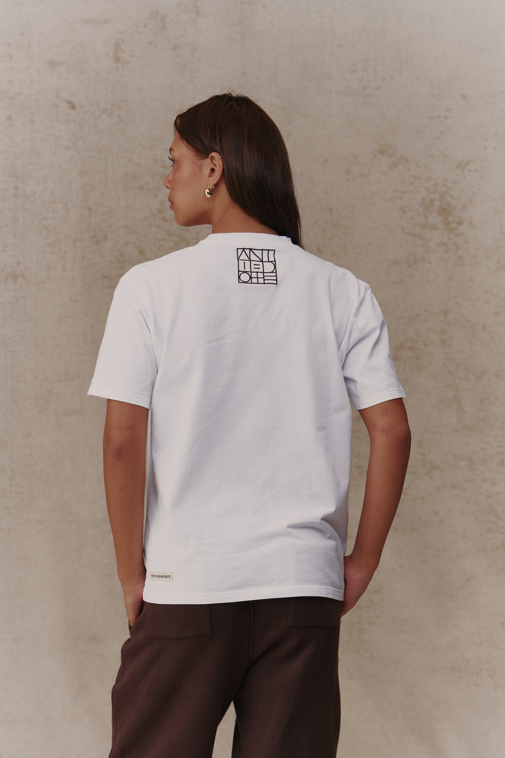 Woman wearing the Antidote Reset Tee in Crisp White, back view