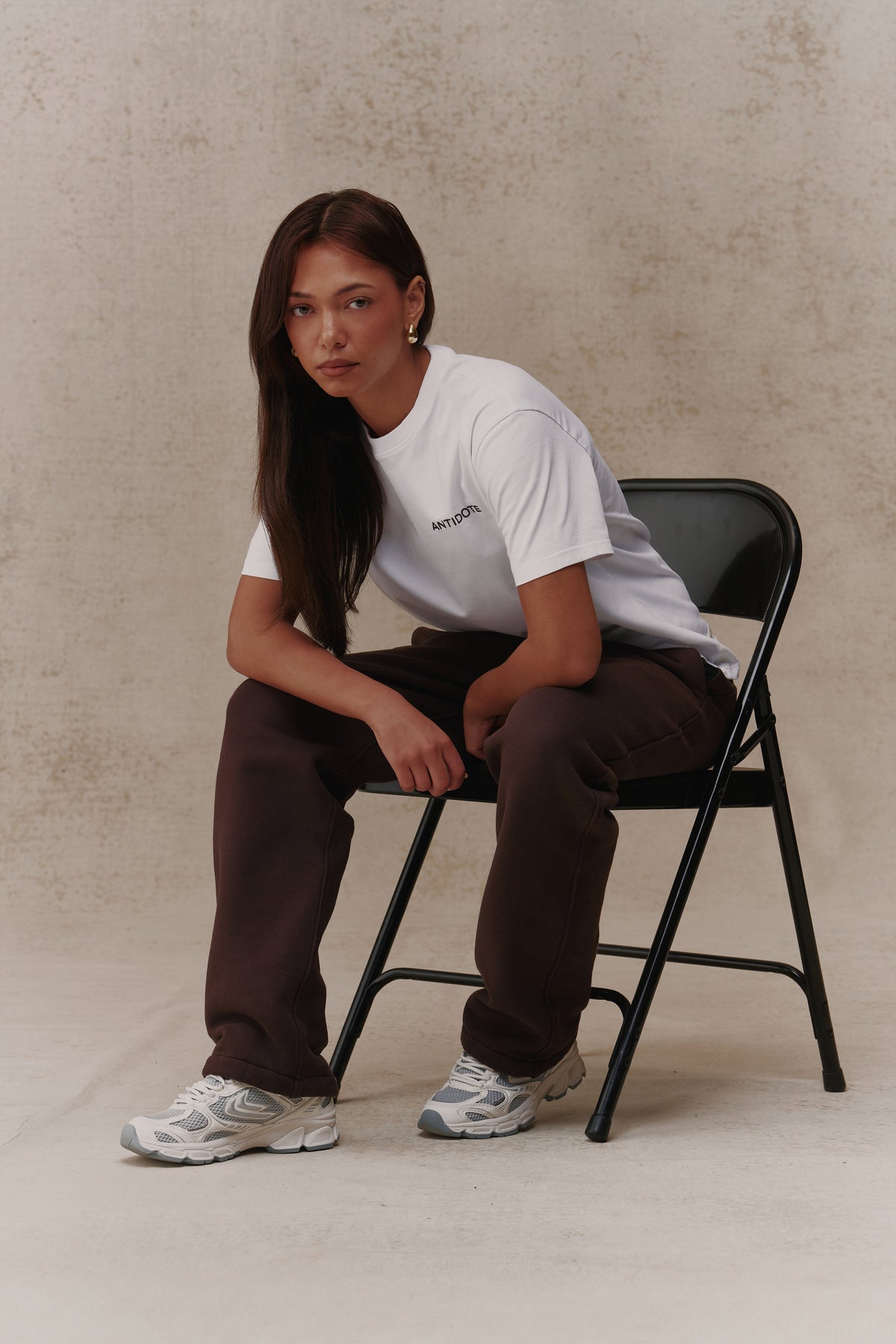 Woman wearing the Antidote Reset Tee in Crisp White, seated