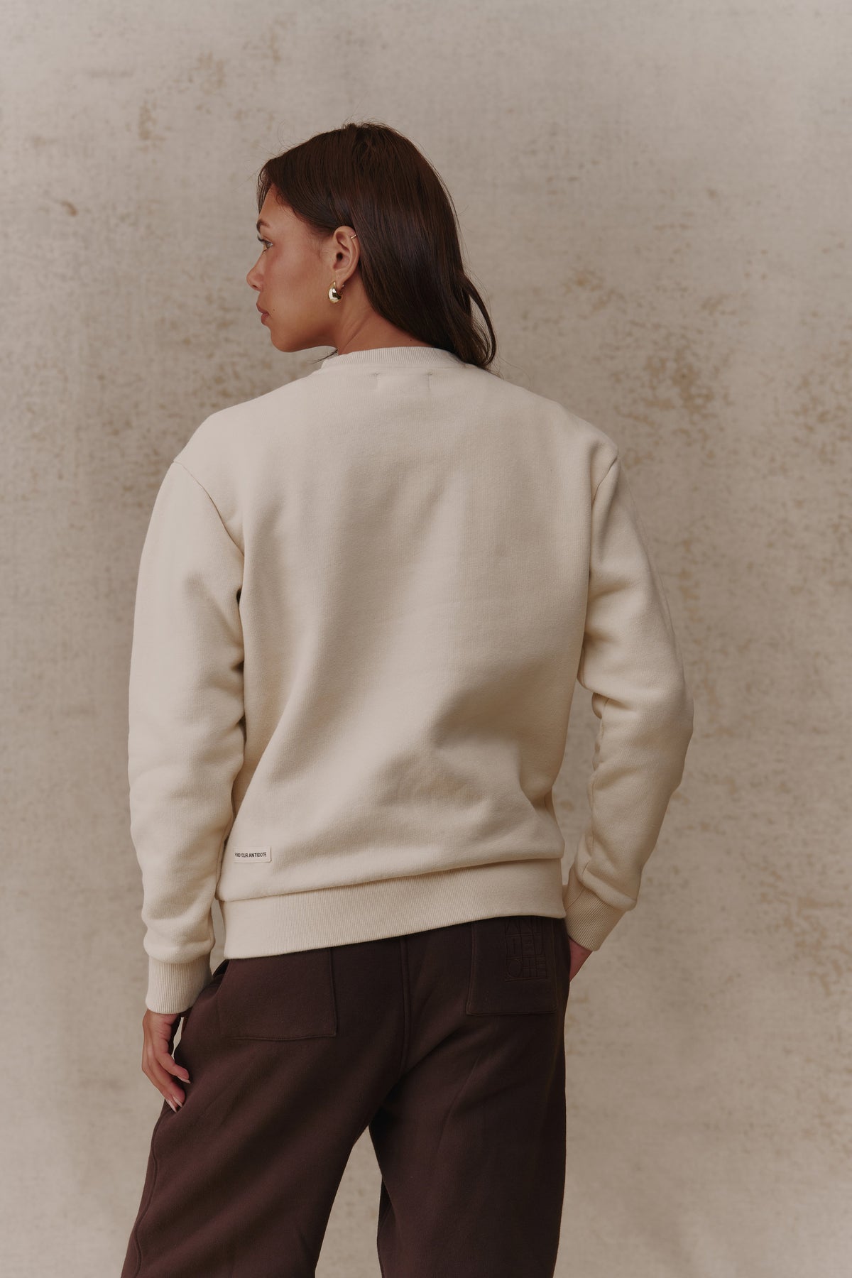 Woman wearing the Antidote Revive Sweatshirt in Sand, back view