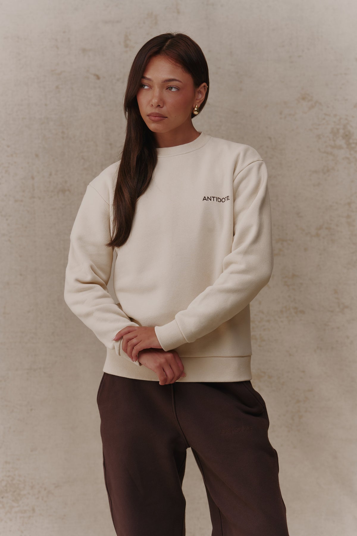 Woman wearing the Antidote Revive Sweatshirt in Sand, three-quarter view
