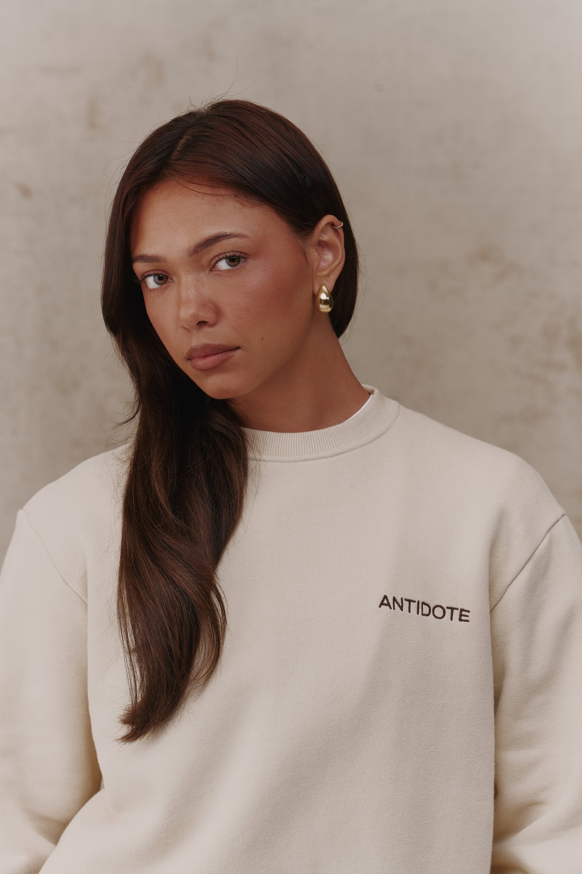 Woman wearing the Antidote Revive Sweatshirt in Sand, close-up front view